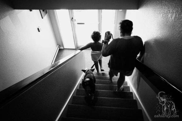 Mother and daughter exit apartment with dog