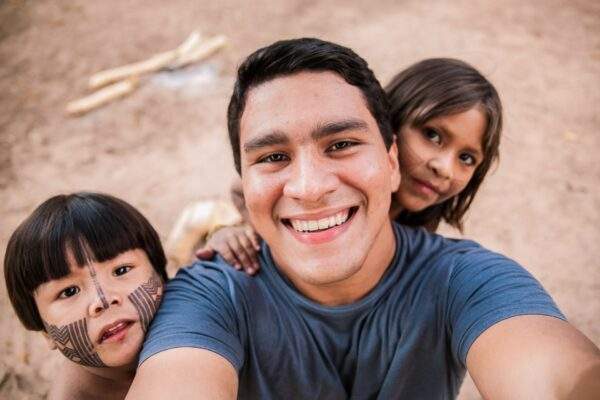 father's selfie with two children hanging off of him