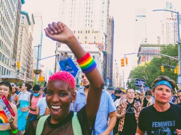 person with pink hair and pride armband at pride march