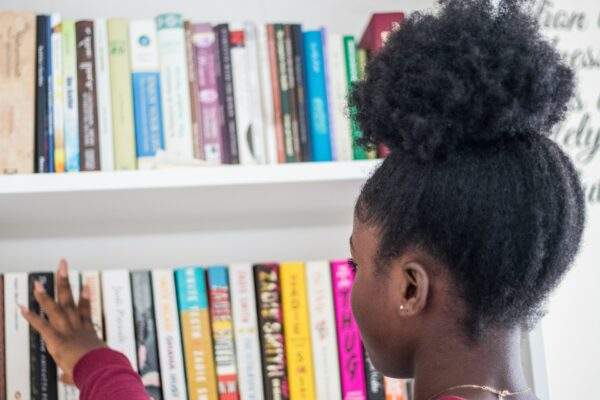 black girl reviewing bookshelf